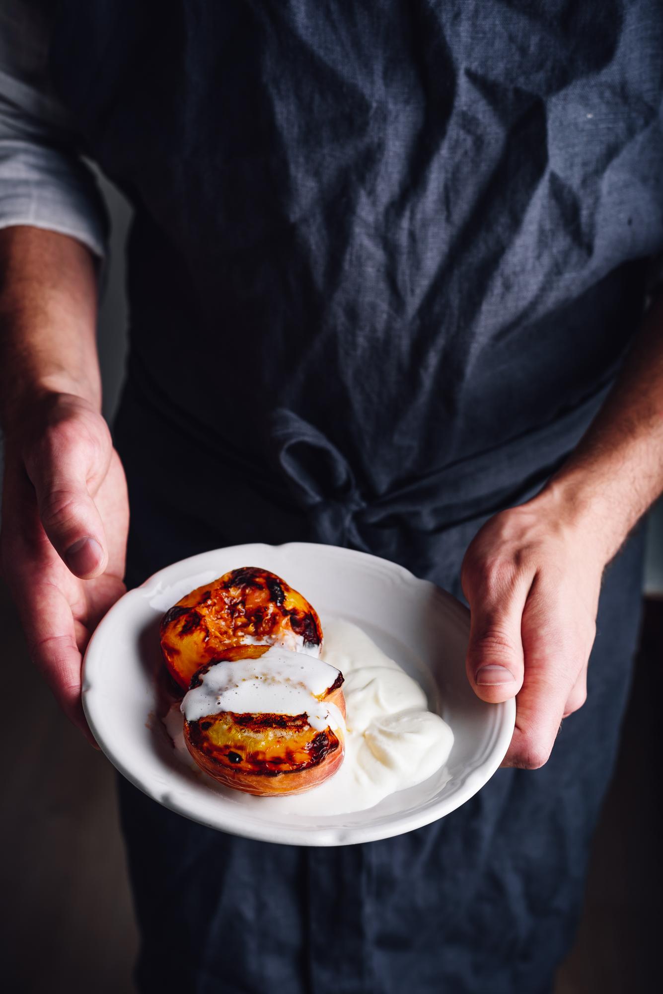 Chef demonstrating plated dish in elegant kitchen
